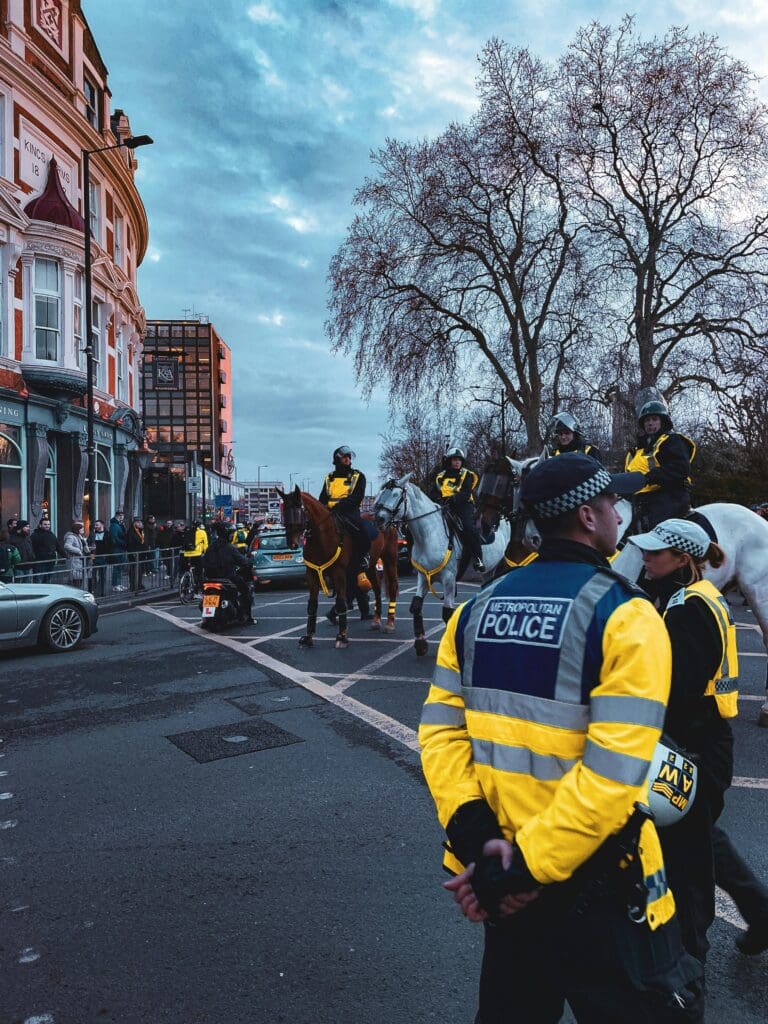 Police officers and mounted police patrolling in an urban street.