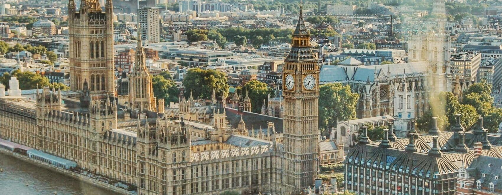 Stunning aerial view of London's iconic Big Ben and the river Thames under daylight.