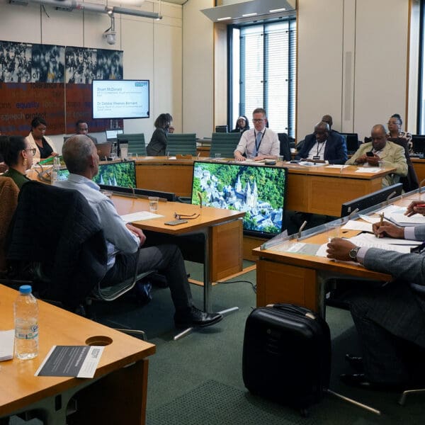 People in a board meeting all in formal attire, discussing Windrush policy