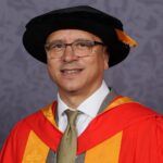 Dr Jeremy Crook OBE clutching a scroll.