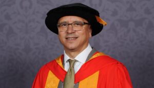 Dr Jeremy Crook OBE clutching a scroll.