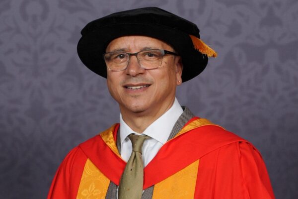 Dr Jeremy Crook OBE clutching a scroll.