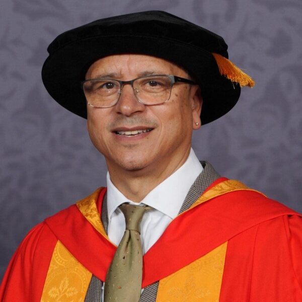 Dr Jeremy Crook OBE clutching a scroll.