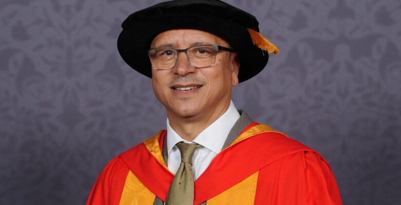 Dr Jeremy Crook OBE clutching a scroll.